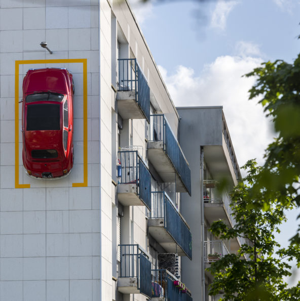 La Fiat 500 de Monsieur Bourgogne est stationnée à la verticale sur la façade d'un immeuble